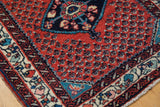Rich red field and detailed ivory floral border of a finely woven vintage Engelas rug corner.