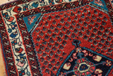 Finely knotted pile of a vintage Engelas rug corner with rich red, teal, and floral ivory borders.