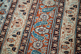 Fine weave of a collector Tabriz rug showing intricate floral stripes in rust orange and aqua blue.