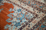 Angled detail of an antique Tabriz rug's fine weave, with aqua blue and saffron highlights.