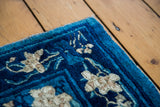 Corner of an antique Chinese Peking rug: cobalt blue, blossoming lotus, delicate tendril motifs.