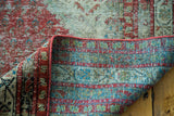 Folded antique Malayer rug showing distressed Mir-boteh pile and finely hand-knotted back.