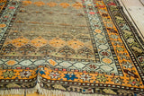 Section of antique Caucasian runner, featuring distressed orange geometric patterns and fringe.