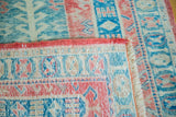 Distressed raspberry red, seafoam, aqua geometric patterns on a vintage Turkish rug.