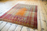 Distressed vintage Turkish Kula prayer rug, burnt orange mihrab, geometric animal motifs.