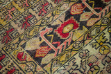 Distressed Kula rug texture showing geometric foliage in burnt orange and charcoal.