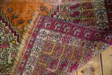 Fringed edge and geometric animal motifs on a distressed burnt orange Turkish Kula rug.