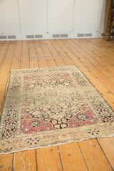 Antique Farahan Sarouk rug viewed from an angle, showcasing its full design layout.