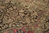 Intricate charcoal and raspberry floral patterns on the low pile of an antique Farahan Sarouk rug.