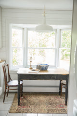 Antique Farahan Sarouk rug with a traditional design grounding a small dining set.