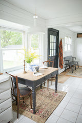 Antique Farahan Sarouk rug with raspberry and charcoal tones styled in a farmhouse dining area.