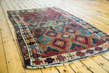 Antique Jaff Kurd rug's geometric patterns, brilliant jewel tones, and heavy decorative wear.