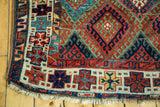 Antique Jaff Kurd rug corner, showing brilliant jewel-toned geometric patterns and heavy wear.