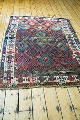 Distressed antique Jaff Kurd rug showing heavy wear, splits, and jewel-tone geometric patterns.