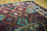 Textured distressed Jaff Kurd rug showcasing ruby red, sapphire blue geometric motifs.