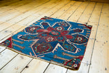 Antique Caucasian fragment: rich red medallion and vibrant blue field patterns.