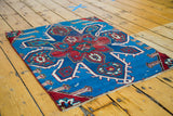 Expressive red and blue geometric patterns with asymmetrical details on the antique Caucasian rug.