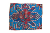 Antique Caucasian rug fragment featuring a vibrant blue field and expressive red geometric medallion.