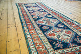 Antique Caucasian runner with distressed indigo field, geometric medallions, and original edges.