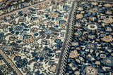 Hand-seamed border detail on antique Persian Farahan Sarouk rug, contrasting ivory and navy floral designs.