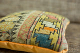 Unique hand-knotted geometric motif in orange, yellow, and blue on the antique Caucasian pillow.
