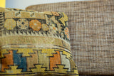 Textured, hand-knotted antique Caucasian fragment pillow featuring geometric orange and yellow designs.