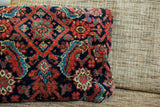 Soft wool surface of the Mahal pillow with intricate red and deep blue pattern.