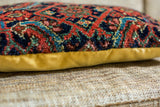 Intricate patterned wool surface and mustard yellow backing of the Mahal fragment pillow.