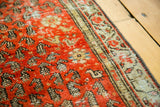 Antique Malayer rug with distressed brick red field, repeating boteh, and secured patterned border.