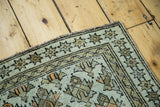 Detail of antique Caucasian rug, geometric star border, distressed earth tones, and orange accents.