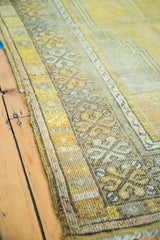Detailed view of the distressed side border on the gold and beige Turkish prayer rug.