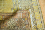 Distressed gold field, secure fringe, and patterned reverse of a vintage Turkish rug.