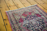 Distressed antique Kerman rug's floral medallion and blossoming motifs.
