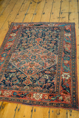 Antique Bijar rug's central salmon medallion, with navy field and intricate Herati pattern.