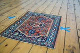 Vintage Persian Hamadan rug's rusty brick red field, herati motifs, and blue border.
