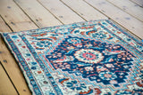 Expressive ivory medallion and stylized herati motifs on a vivid blue vintage Hamadan rug.