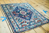 Vintage Hamadan rug corner, revealing stylized ivory border motifs and deep blue field.