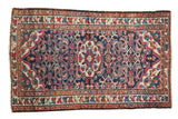 Vintage Persian Lilihan rug with a dark blue field, floral bouquets, and meandering border.