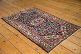 Vintage Persian Lilihan rug's dark blue field with colorful floral bouquets and meandering border.