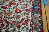 Vintage Hamadan rug, patterned border with red and blue flowers, and secured side edge.