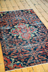 Dargezine rug fragment corner, showing navy field, sky blue, red Herati motifs, and fringe.