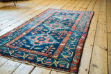 Vintage Hamadan runner with geometric medallions, germinating plants, and gem tones on dark blue.