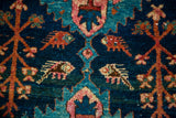 Detail of vintage Hamadan rug showing geometric fish motifs and germinating plants on indigo.