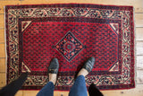Vintage Persian Serbend rug with cherry red field, repeating Mir geometric design, and intricate border.