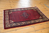 Vintage Persian Serbend rug's small diamond medallion, cherry red Mir pattern, and geometric tendrils.