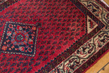 Vintage Persian Serbend rug corner, red Mir field, blue-red curvilinear design, beige border.