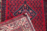 Folded corner of the traditional Persian Serbend rug, showing fringe and intricate border.