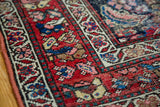 Distressed red and blue pile with intricate border on a late 19th century Northwest Persian rug.