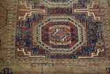 Close-up of antique Belouch rug's geometric tribal medallion in navy and chestnut.