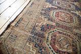 Antique Belouch rug showcasing tribal geometric patterns in rich chestnut, navy, and tobacco hues.